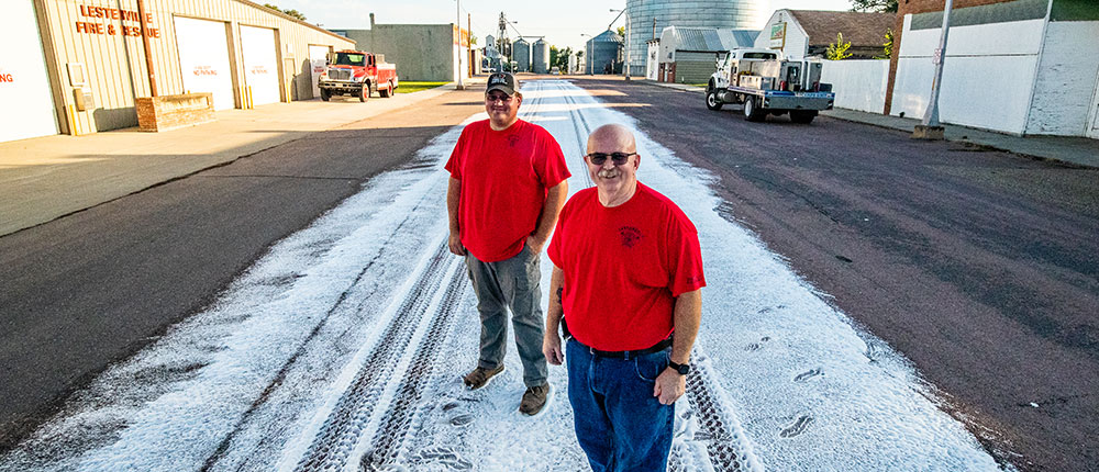 Two Lesterville Fire Department firefighters standing on a trail of foam